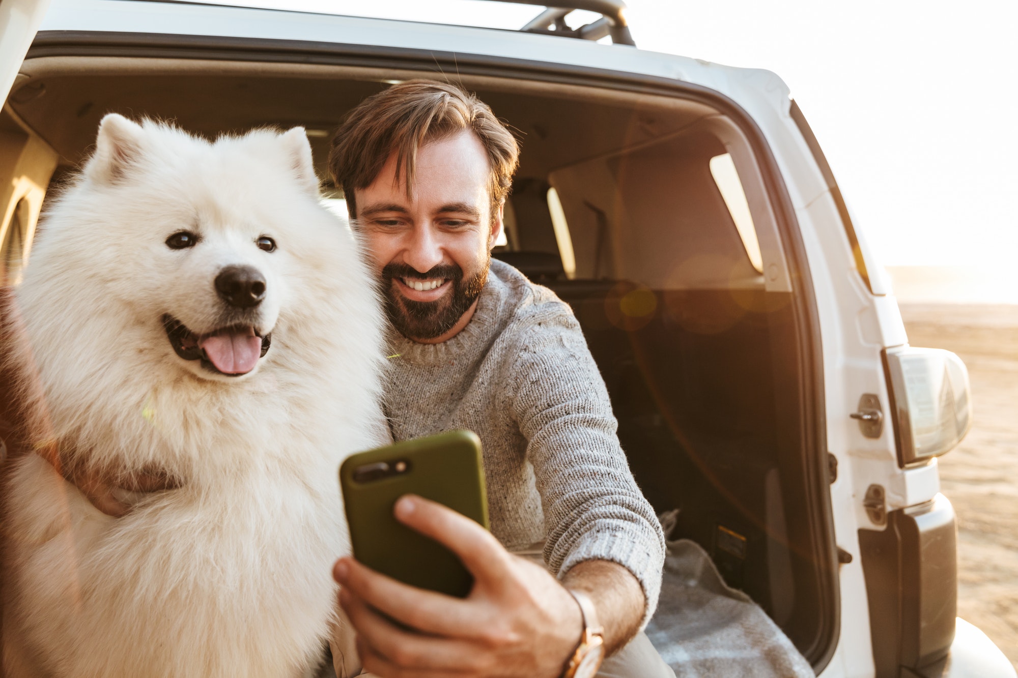 man-with-dog-samoyed-outdoors-at-the-beach.jpg